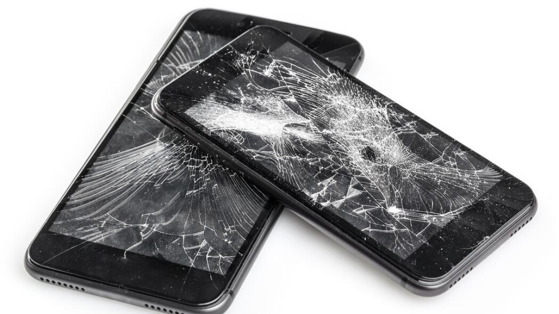 Phone with shattered screen lying on table
