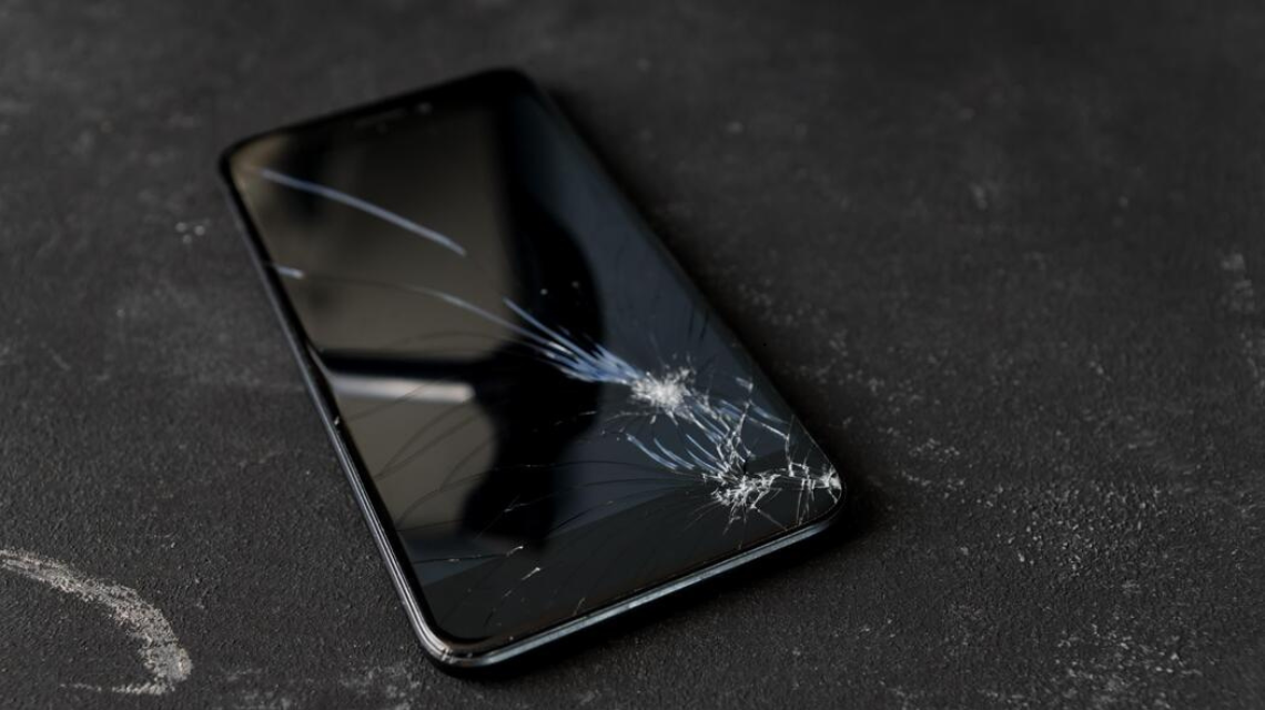 Damaged mobile phone screen with multiple cracks